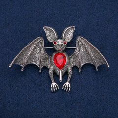 Брошка-кулон Летюча миша сріблястий метал з червоними стразами і червоним каменем 77х55мм + - купити біжутерію