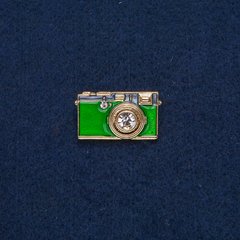Брошка Фотоапарат золотистий метал із зеленою емаллю і білими каменями 30х17 мм + - купить бижутерию дешево