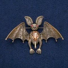 Брошка-кулон Летюча миша золотистий метал з червоними стразами і жовтим каменем 77х55мм + - купити біжутерію