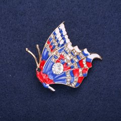 Брошка Метелик з білими стразами синя і червона емаль 40х38мм жовтий метал купити біжутерію дешево в інтернеті